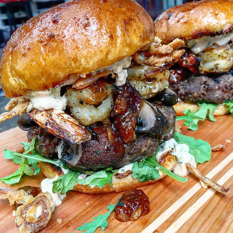 Smokey Sweet Surf and Turf Burgers with Grilled Portobellos Gorgonzola Aioli Bacon Fig Jam and Fried Red Onions